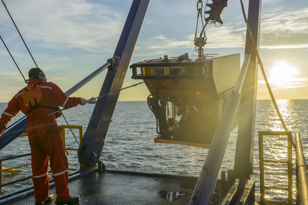 Worker recovering robotics Remote Operated Vehicle (ROV) after entering sea surface during oil and gas pipeline inspection in the middle of South China Sea.
