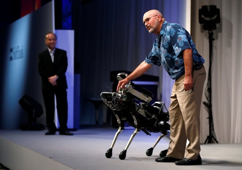 Boston Dynamics CEO and founder Marc Raibert, seen with the SpotMini robot, says he doesn