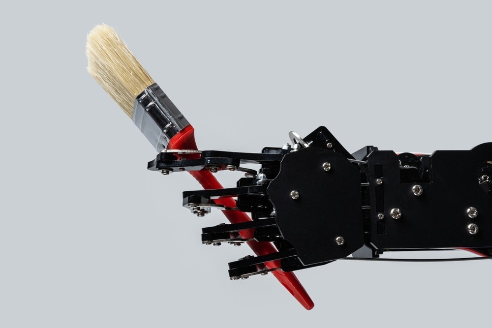 Real robotic hand with paintbrush. Concepts of Artificial intelligence development or job replacement by AI.