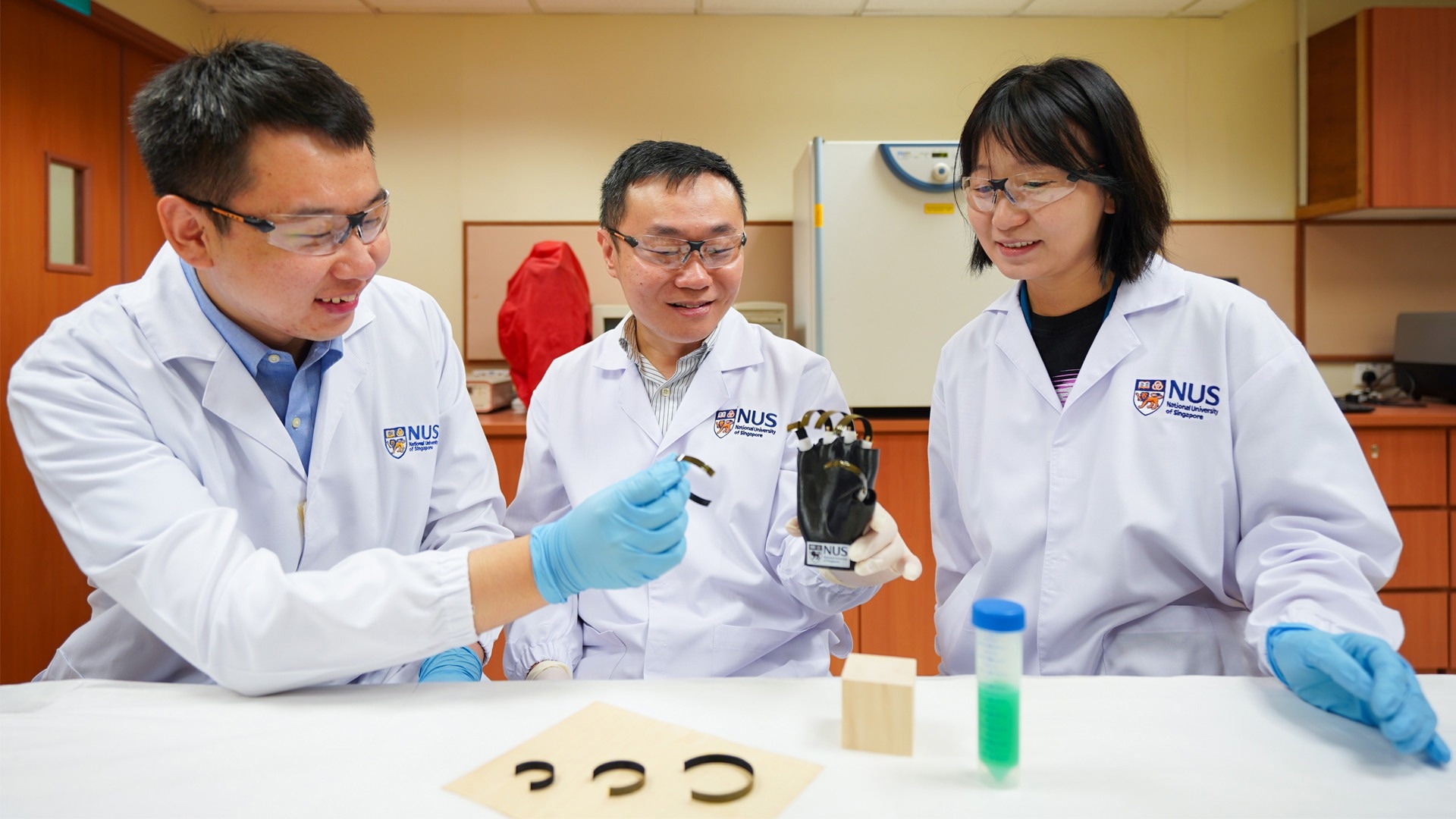 Asst Prof Tan Swee Ching (center), together with team members Mr Qu Hao (left) and Ms Bai Lulu ((right), have developed a wooden gripper that is driven by changes in moisture, temperature, and lighting in the environment.